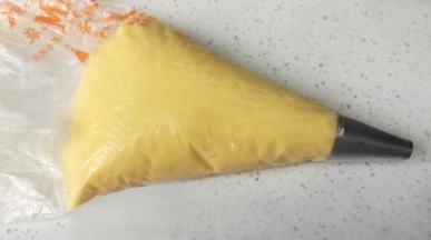 装入裱花袋，裱花嘴为直径1cm的圆形，模具垫上纸托。