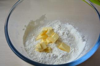 低筋面粉、糖粉、盐过筛入盆中，黄油切小块同入粉盆中