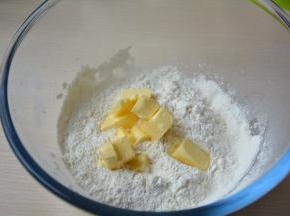 低筋面粉、糖粉、盐过筛入盆中，黄油切小块同入粉盆中