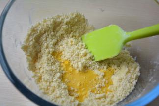 用刮刀将黄油和粉类混合成小粒粒状，然后将蛋黄打散加入粉粒中
