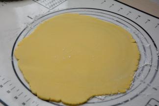 冷藏变硬的面团取出来，在揉面垫上撒少许面粉，在面团上也撒少许面粉，擀成厚约3毫米的面片，厚度也随派盘大小来调整