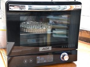 预热时间结束将派皮送入预热好的烤箱中层，按“启动”键，烤箱开始烘烤