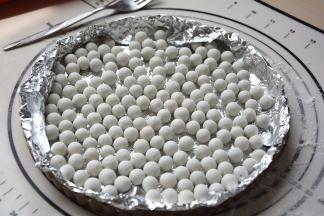 用锡纸将派皮罩住，上面铺烘焙石，用绿豆红豆也可以