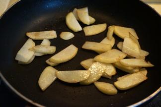 煎好的香肠盛出，锅中留底油，将土豆片煎至周边焦黄