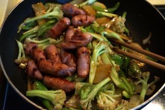 待味道均匀分布在菜料中时，将珍妮香肠倒回锅中，撒小米辣，翻炒几下，出锅