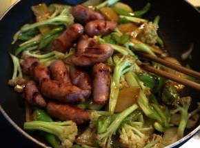 待味道均匀分布在菜料中时，将珍妮香肠倒回锅中，撒小米辣，翻炒几下，出锅