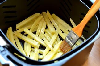 10分钟的时候，将炸篮拉出来，摇晃几下，使薯条均匀散开，再用刷子随意在上面抹几下油，重新推入炸锅中