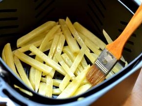 10分钟的时候，将炸篮拉出来，摇晃几下，使薯条均匀散开，再用刷子随意在上面抹几下油，重新推入炸锅中