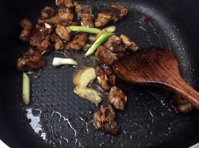 炒至排骨上色了就放入姜片和蒜苗头翻炒