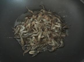 热锅冷油后将洗净沥干水分的河虾放入锅中油爆（可以用洁柔纸巾吸去河虾的水分再放入油锅中）