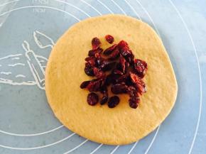 取一个面团擀圆擀薄，放上蔓越莓干