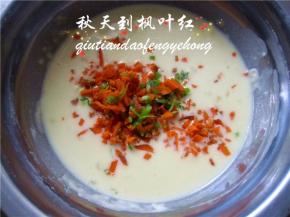 将切碎的胡萝卜和葱碎放入蛋糊中。