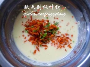 将切碎的胡萝卜和葱碎放入蛋糊中。