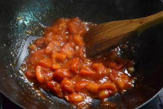 放入番茄块翻炒，炒出汁后加入番茄酱炒至粘稠状