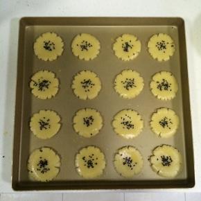 在桃酥表面上撒少许黑芝麻。