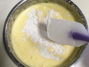 在打发好的蛋糊中分两次加入低粉翻拌均匀（提前把低粉过筛备着），剩下一点低粉加入橙汁和玉米油混合的液体中拌匀。