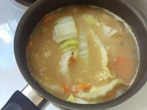 再加入大白菜和虾仁，鱿鱼，煮的沸腾加入盐巴就可以咯。