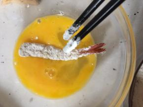 再将虾放入鸡蛋液中滚一下