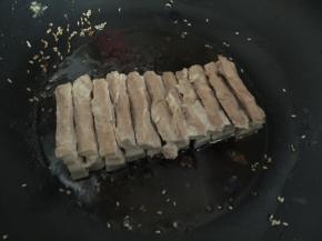 然后锅里热油后将五花肉肉皮朝下炸至表皮金黄