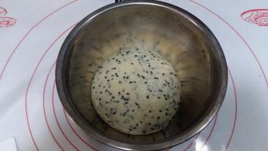 倒入黑芝麻，揉匀。收圆后，放容器内，盖保鲜膜进行发酵。