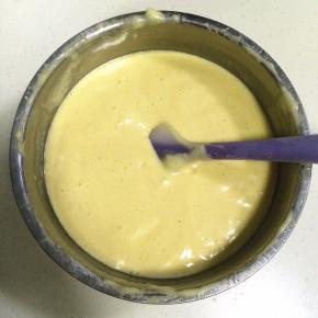 把拌好低筋面粉、橙汁和玉米油的混合糊加入到蛋面糊中，继续翻拌均匀。