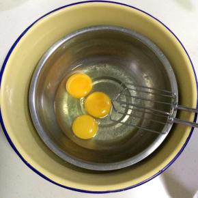 把鸡蛋打入打蛋盆内，坐在放有热水的盆内。