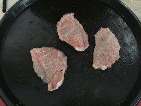 电饼铛上涂抹适量油，将洗净的猪肉片放在电饼铛里煎