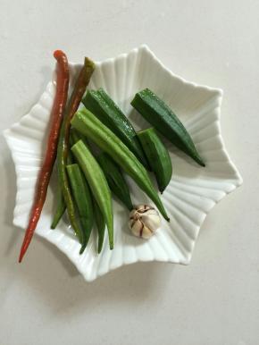 准备好所需的食材：

新鲜的嫩秋葵200克，红尖椒2个，蒜瓣1个！（秋葵是我家菜园里长得，采摘的有点儿晚，有的都有点儿老了，我就把老的部分去掉了！如果买的是嫩嫩的秋葵就不用去掉，免得营养流失！）

