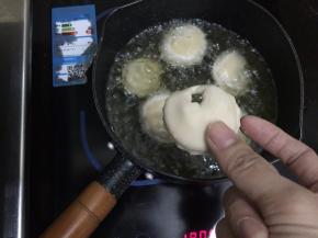 17. 把饺子折子的那一面朝下的放入油锅，这一步是为了让折子定形炸出来会更漂亮，所以一定要把折子朝下