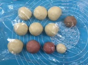 10. 把面团分成7份，7份32克其中1份加入可可粉揉均匀，剩余的分割成平等的2份，一份加红曲粉揉均匀，再分割出原味和加了红曲粉的面团各35克