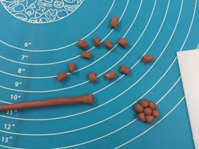 13. 把面团揉成长条状，再分割出21等份每个为1克，揉圆码成小花形状即可