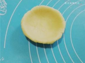 用两手的拇指将挞皮面团捏成挞模的形状。厚薄要均匀，边缘要整齐；