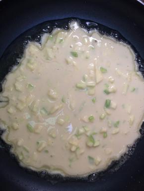 平底锅热油，舀一勺面糊放入锅中，用小火慢煎