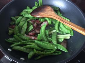 然后加入腊肠和蒜段头炒