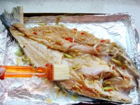 烤盘里铺上锡纸，放入腌好的鱼，表面刷上少许食用油。