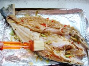 烤盘里铺上锡纸，放入腌好的鱼，表面刷上少许食用油。