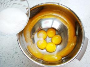 先制作蛋黄糊：80克的白砂糖分出10克加入蛋黄里，加入盐。