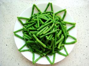 豆角放入盘中，周边摆放出花边。