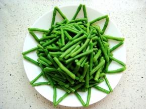 豆角放入盘中，周边摆放出花边。
