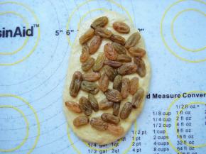 均匀的铺上一层葡萄干，稍微按几下。