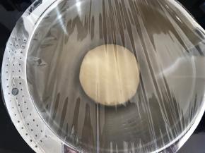 将面团从面包机中取出，团成圆放盆里盖上保鲜膜进行一次发酵。夏天温度高，我直接放在温暖处室温发酵。