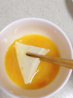 鸡蛋打在碗里加少许盐拌匀，用筷子把切好的豆腐夹在碗里粘上蛋液。