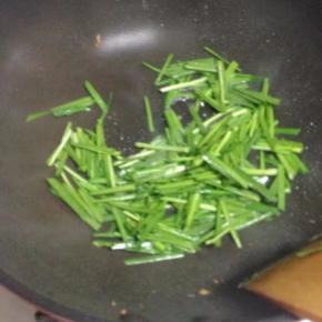 锅里留油底，倒入韭菜翻炒