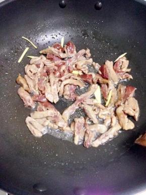 锅里倒入油，加入姜丝和牛肉，大火炒至牛肉变色然后盛出。