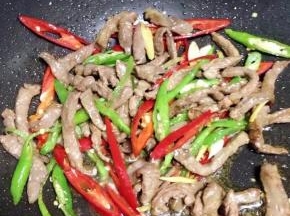 杭椒微软后，加入炒好的牛肉翻炒匀。