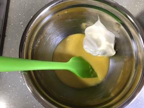 将小部分蛋白霜加入蛋黄糊，用翻拌的手法翻拌均匀。