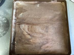 倒入已提前铺好油纸的烤盘，抹平表面，轻拍底部震出大气泡。