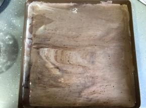 倒入已提前铺好油纸的烤盘，抹平表面，轻拍底部震出大气泡。