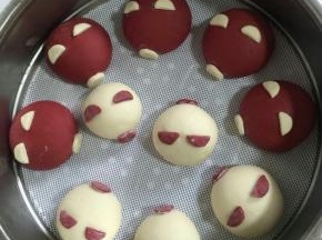 把做好的鼻子和耳朵用手指沾少许水，安在猪头上！
