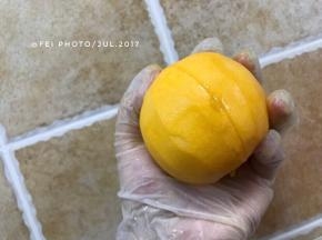 接下来，我们去掉黄桃的核，把肉剥下来。我们拿一把顺手的小刀，如图，用刀从上到下切一刀，切到底，切到核。